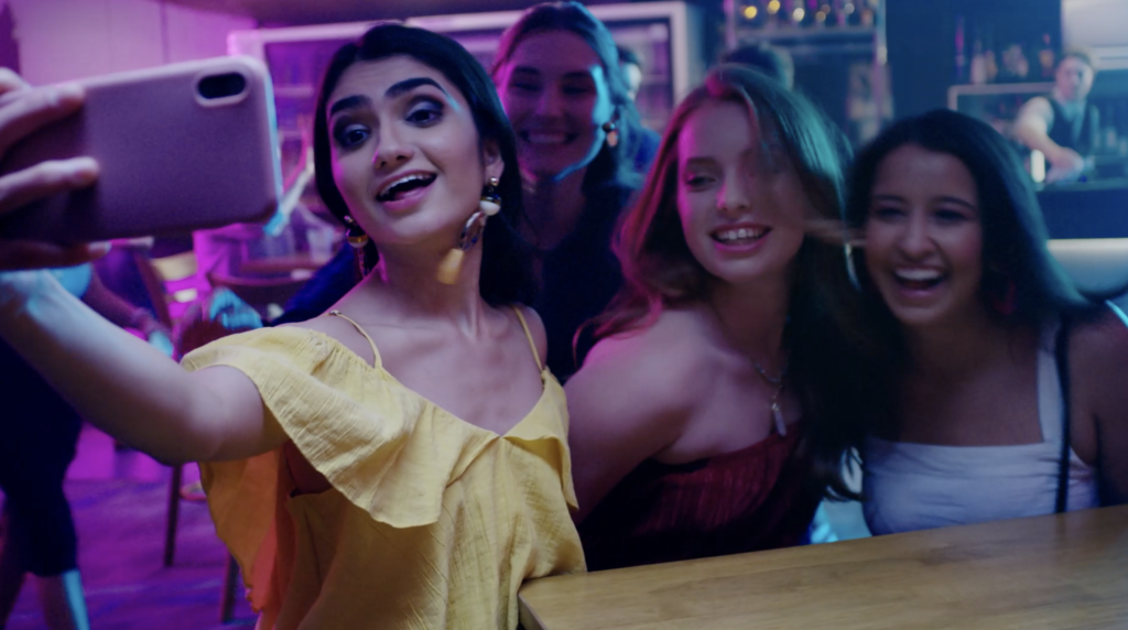 Brisbane-based Peachy Keen Colourist Angela Cerasi colour graded this shot of young women smiling for a selfie at a club, for the "Covid Young Adults" TVC campaign for Queensland Health, networking for introverts