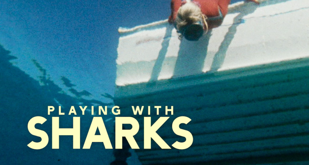 Brisbane-based colourist Angela Cerasi from Peachy Keen Colour graded this title card of Valerie Taylor, reflected in the water leaning over a boat, with the yellow text "Playing With Sharks" over it, for the documentary "Playing With Sharks"