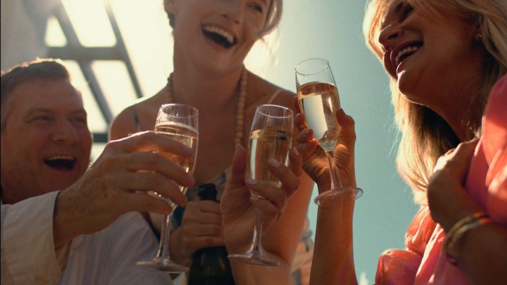 Peachy Keen Colourist Angela Cerasi did the warm and bold colour grade of this shot of smiling people toasting with champagne, the sun bright behind them, for the TVC "Brand Campaign - Lottery" - for Living Gems Retirement resorts, tips on networking for introverts in the screen industry