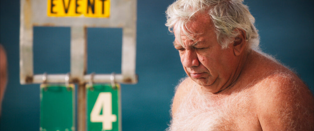 Colour Graded image of a man at a swimming pool for the documentary The Pool